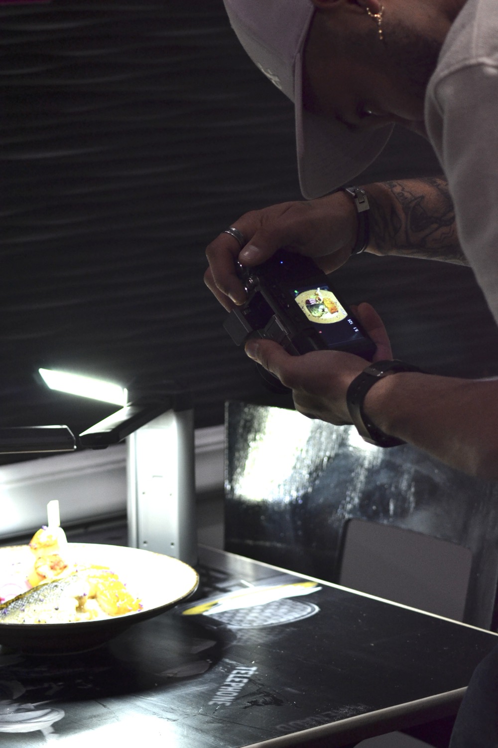 Photographe vérifiant un cliché d'assiette sur l'écran de son appareil