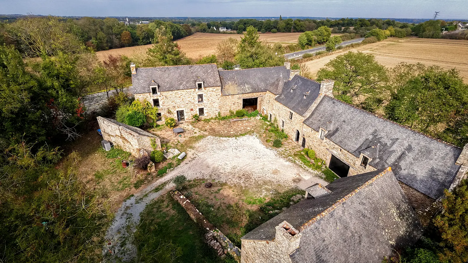 La même longère vue de drone, avec sa cour et la campagne autour