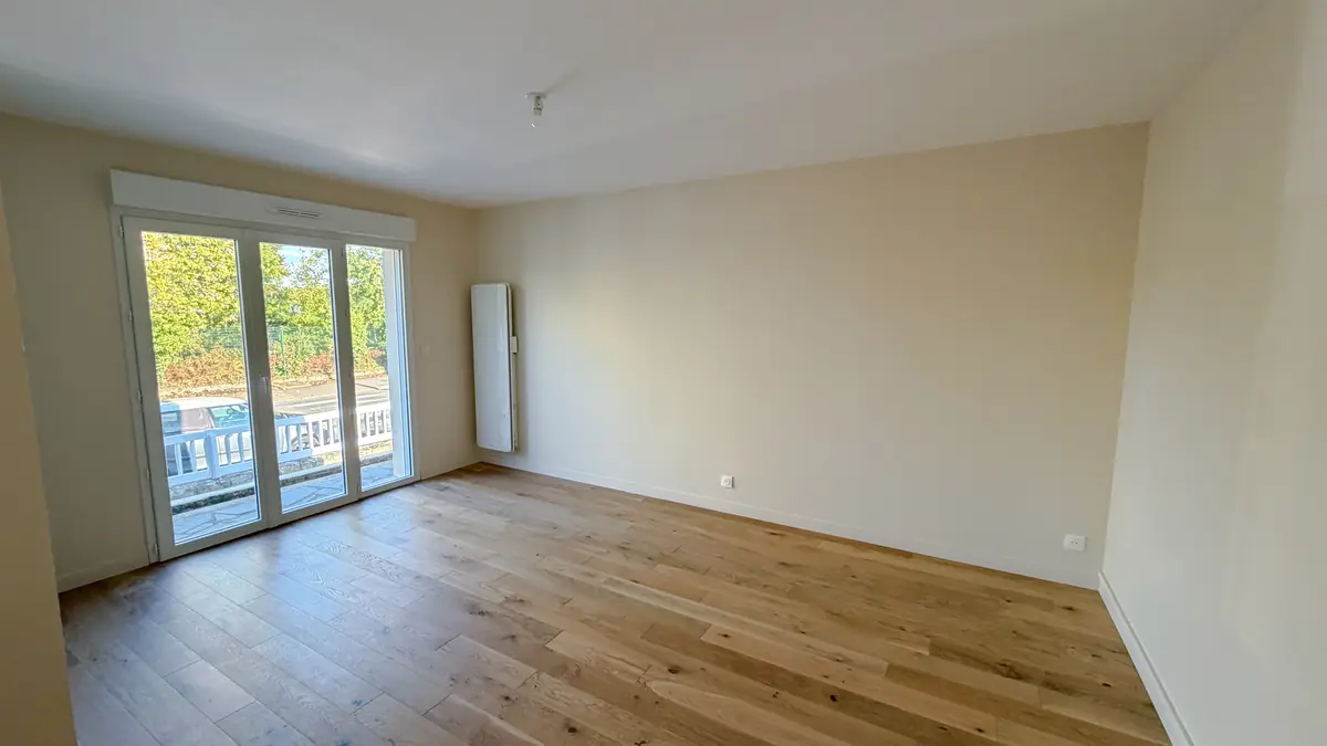 Séjour lumineux avec parquet et baie vitrée